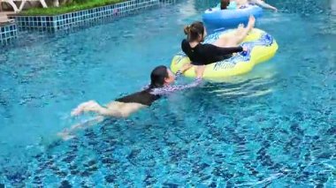 İki insan şişme havuzun keyfini çıkarıyor.