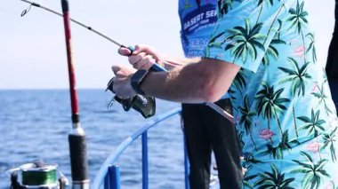 Tayland, Phuket 'te teknede balık tutan bir adam.