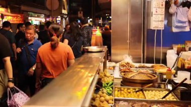 Kalabalık hareketli sokak yemekleri pazarının keyfini çıkarıyor