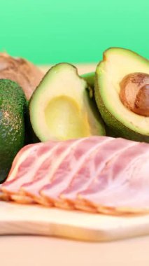 Avokado, yağ, fındık ve zeytinlerin canlı bir şekilde sergilenmesi, sağlıklı yağ kaynaklarını vurguluyor.