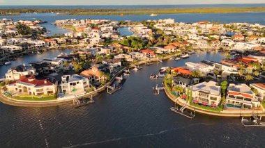 İnsansız hava aracı görüntüleri, Gold Coast, Avustralya 'da sakin sular ve canlı çevrelerle sıcak güneş ışığı altında lüks deniz kenarındaki evleri yakalıyor.