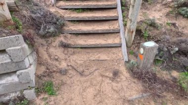 Kumlu, gür bir çevrede ahşap merdivenler.