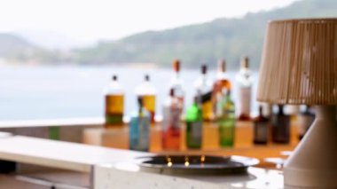 Phuket, Tayland 'da denize bakan bulanık şişeler ve bir lambayla sakin bir sahil barı.