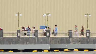 Nehir kenarında yürüyen yayalar.