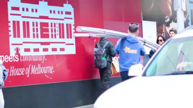 Park halindeki bir arabanın yanında insanlar etkileşime geçiyor.