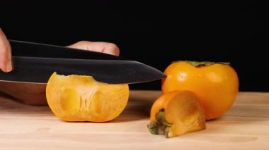 Bir el dikkatlice olgun bir hurma dilimliyor.