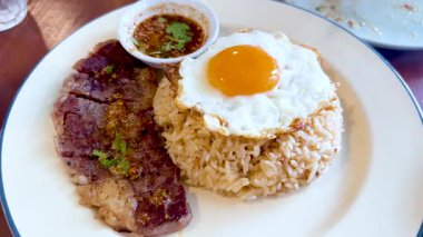 Biftek ve pirinç dilimlenmiş yumurta sarısı.