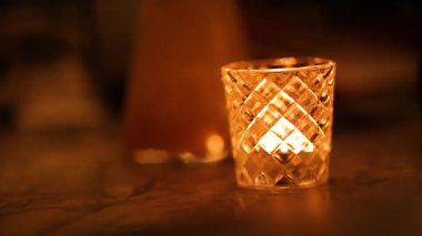 Cam tutacağında titreyen bir mum sıcak ve samimi bir atmosfer yaratır. Yumuşak ışıklandırma, rahat ve huzurlu havayı arttırır.