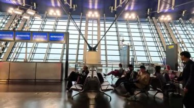 Terminalde bekleyen ve yürüyen gezginler