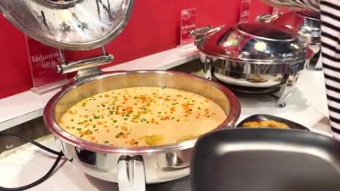 Bir insan açık büfeden Kore buğulama yumurtası servis eder.