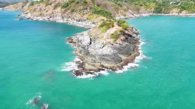 Tayland, Phuket 'teki Promthep Burnu' nun kayalık kıyı şeridini ve turkuaz sularını gün ışığında gösteren hava görüntüleri.