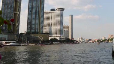 Tekneler işlek bir nehir kıyısından geçiyor