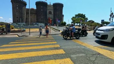 Tarihi Napoli kalesi yakınlarında scooter 'lar ve yayalar.
