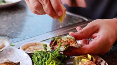 Eller istiridyeleri otlar ve limonla hazırlıyor.