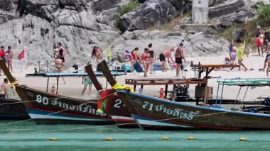 Phuket 'te canlı bir sahil, tekneleri ve güneşin tadını çıkaran insanlar. Canlı renkler ve dinamik hareketler yaz atmosferini yakalar