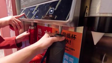 Eller su dağıtım makinesini çalıştırıyor