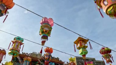 Tapınak ve gökdelenlerin yanında asılı fenerler