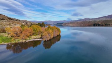 İnsansız hava aracı Dunstan Gölü üzerindeki sakin sonbahar manzarasını canlı yapraklar ve berrak bir gökyüzü altında sakin sularla yakalıyor.
