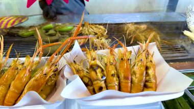 Yüzen markette ızgara karides ve balık