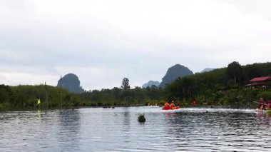 İnsanlar Tayland, Krabi 'deki berrak su kanalında kano gezintisine çıkıyorlar.