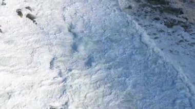 Drone görüntüleri, Avustralya 'nın Byron Körfezi' ndeki kayalık sahil şeridine çarpan dalgaları yakalıyor. Parlak gün ışığı dinamik okyanus manzarasını güçlendirir.