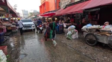 Islak bir yolda ilerleyen insanlar