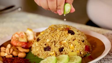 Kızarmış pirinç üzerine limon suyu serpilmiş.