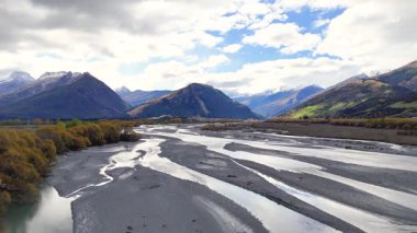 Havadan çekilen görüntüler, Glenorchy, Yeni Zelanda 'nın örülmüş nehir ve dağlık arazisini dinamik bulut örtüsü ve doğal ışık altında görüntüler.
