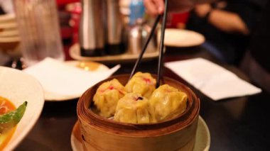 Buharlı sepetten köfte toplayan biri.