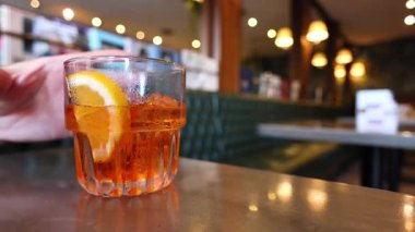 Bir el portakal dilimli bir içki alır.