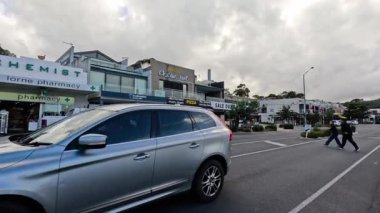 Dükkanların önünde karşıdan karşıya geçen kişi