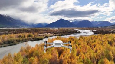 İnsansız hava aracı, dinamik gökyüzünün altındaki görkemli dağlara karşı kurulmuş canlı bir sonbahar ormanı ve dolambaçlı bir nehrin geniş görüntülerini yakalıyor.