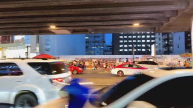 Araçlar ve insanlarla dolu bir sokak sahnesi