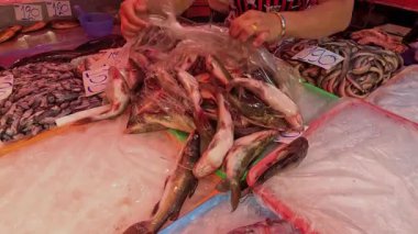 Kalabalık bir pazarda balık ayırıp satmak.