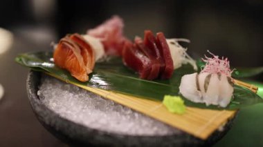 İnsan yemek çubuklarıyla suşi parçaları toplar.