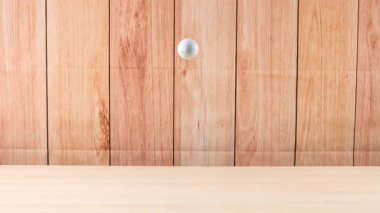 Bir golf topu ahşap zeminde yuvarlanır.