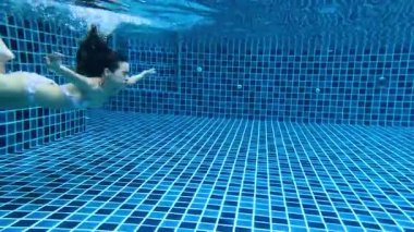 Kadın zarif bir şekilde havuzda yüzüyor.