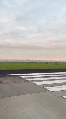 Bulutlu bir günde Auckland Havaalanı 'nda pistte hızla ilerleyen bir uçak görülüyor.