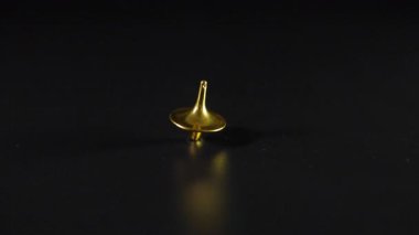 Siyah yüzeyde dönen ve sallanan altın tepeler