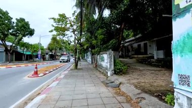 Koh Samui 'de yemyeşil, bulutlu aydınlık ve az trafik olan sakin bir sokak manzarası huzurlu bir şehir ortamı yaratıyor.