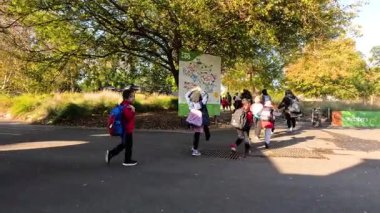 Melbourne Hayvanat Bahçesi girişinde çocuklar birlikte yürüyor.