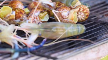 Izgarada karides ve salyangoz pişiyor.