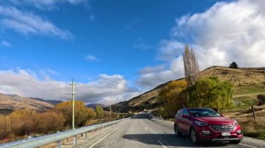 Wanaka, Yeni Zelanda 'da gezintiye çıkmak, sonbahar yapraklarını, açık gökyüzünü ve dağlık araziyi göstermek. Pürüzsüz kamera hareketleri ve doğal ışıklandırmayla