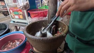 Havanda papaya salatası yapan kişi.