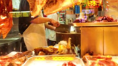 Şef kalabalık bir pazarda gevrek domuz hazırlıyor.