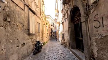 Dar bir sokağa park etmiş bir motosiklet.