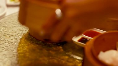 Bir el, Çin Lokantası 'nda, bambu buharlı buharlı tencerelerden, geleneksel bir yemek pişirme anını yakalama imkanı sunuyor.