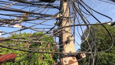 Elektrik direğine dolanmış kablolar ve kablolar