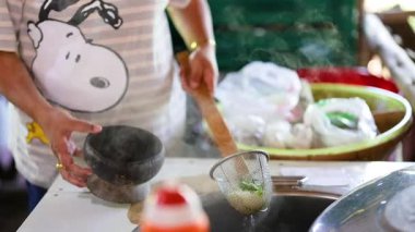Satıcı Bangkok pazarında erişte çorbası yapıyor.