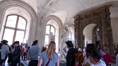 Louvre Müzesi 'ndeki bir koridoru keşfeden ziyaretçiler